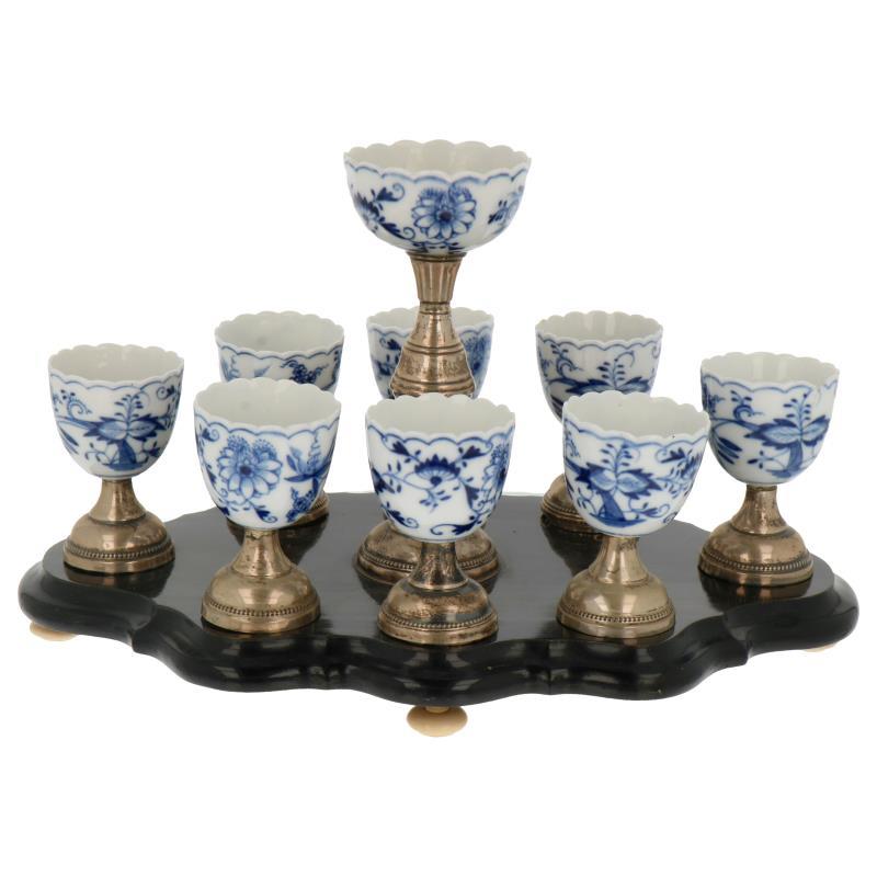 (9) Delige eierdopjes set porselein met zoutbakje op gezwart houten plateau en ivorine pootjes. Mogelijk Mosa porselein Maastricht zilver.