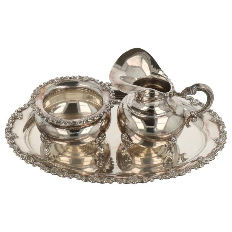 Roomstel met onderblad 3 delig met opgesoldeerde rocaille versieringen afgewerkt zilver.