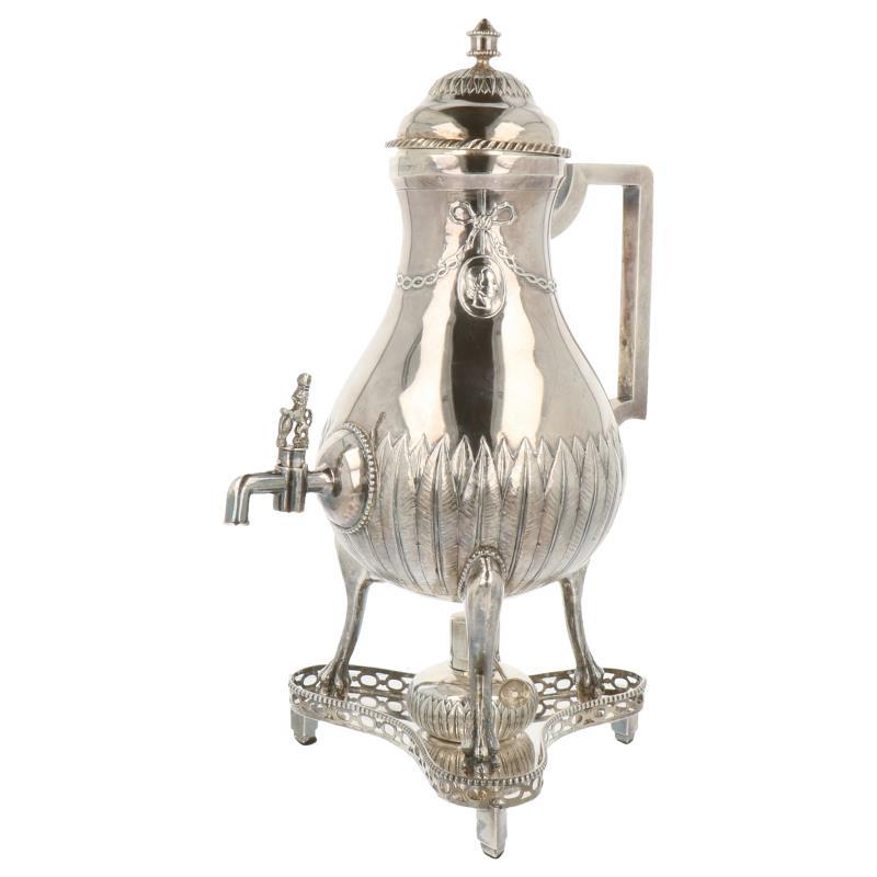 Kraantjeskan op 3 klauwpootjes inclusief onderschaal en brander versierd met gegoten kabelranden, bladmotieven, strik en guirlande versieringen zilver.