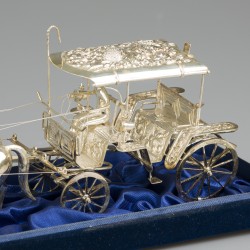 Miniatuur koets met paarden in vitrine, zilver.