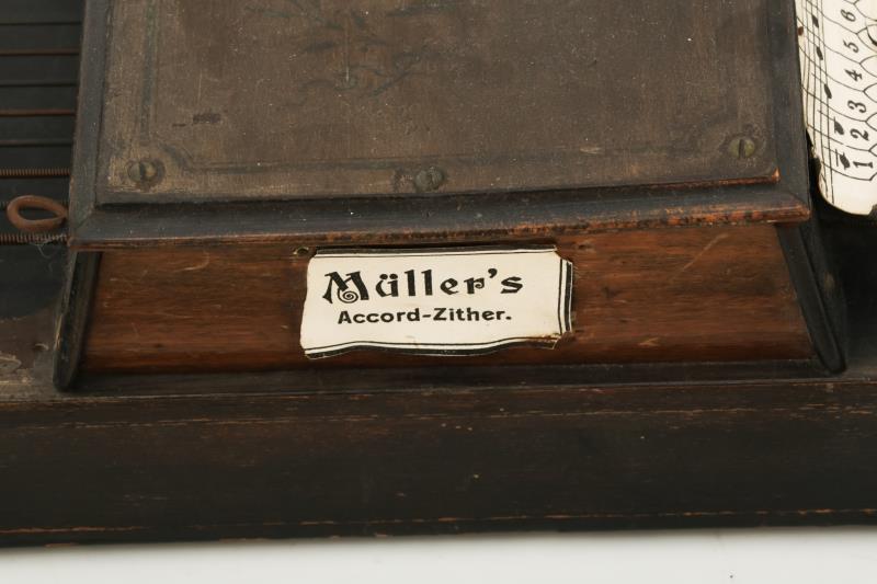 Een autoharp gemerkt: Müller's Accordzither Orpheus, met daarbij drie bijbehorende melodieboekjes, vol. 1, 3 en 4. met stemsleutel.