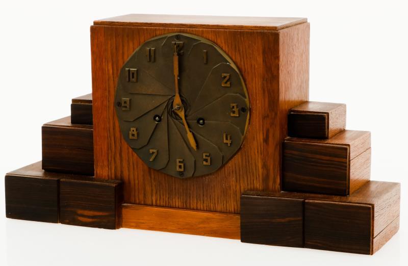 Een art-deco schouwklok in eiken kast met bronzen wijzerplaat, Holland, ca. 1920.