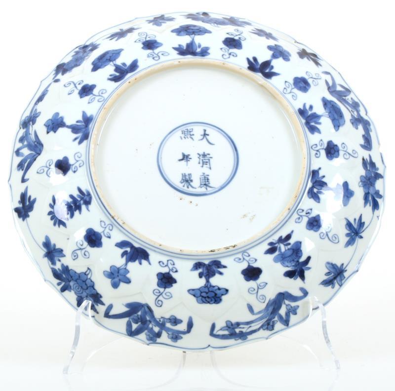 Een porseleinen schotel met decor van twee Chinese dames op een terras, gemerkt in periode. China, Kangxi.