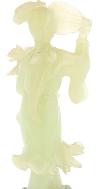 Een in jade vervaardigd figuur in de vorm van een Chinese vrouw met waaier en bloem, incl. sokkel. China, 19e/20e eeuw.