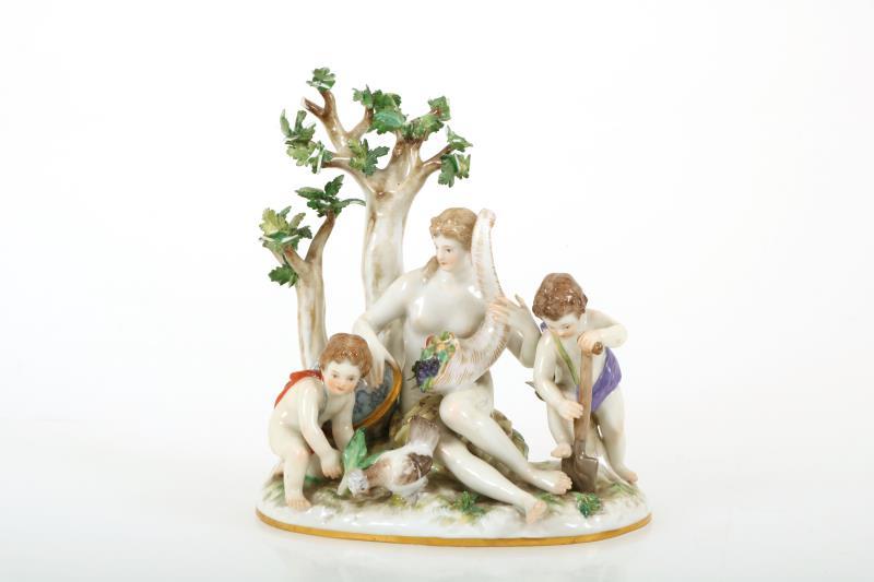 Een polychrome porseleinen beeldengroep met personificatie van de oogst met de hoorn des Overvloeds en twee putti, gemerkt Meissen. Duitsland 19e eeuw.
