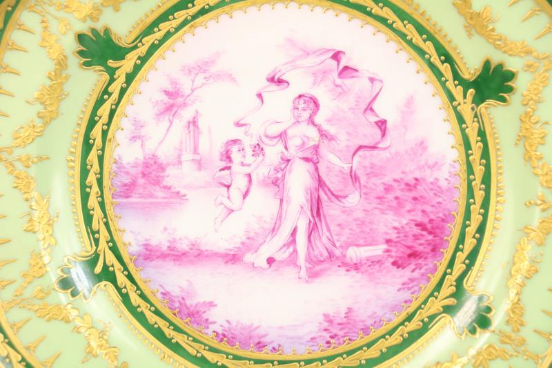 Een porseleinen bord met in het midden een afbeelding van een damen met cupido. Frankrijk, 19e eeuw.