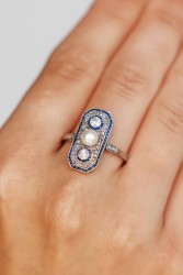 Platina Art Deco ring bezet met ca. 0.20 ct. diamant, saffier en parel.