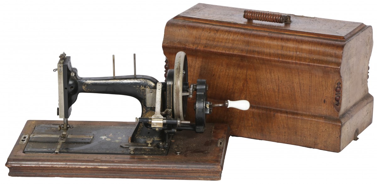 Een naaimachine in houten behuizing, 1e kwart 20e eeuw.
