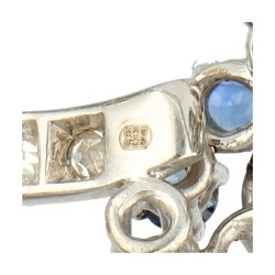 18K Witgouden Q-broche bezet met ca. 1.01 ct. diamant en natuurlijk saffier.