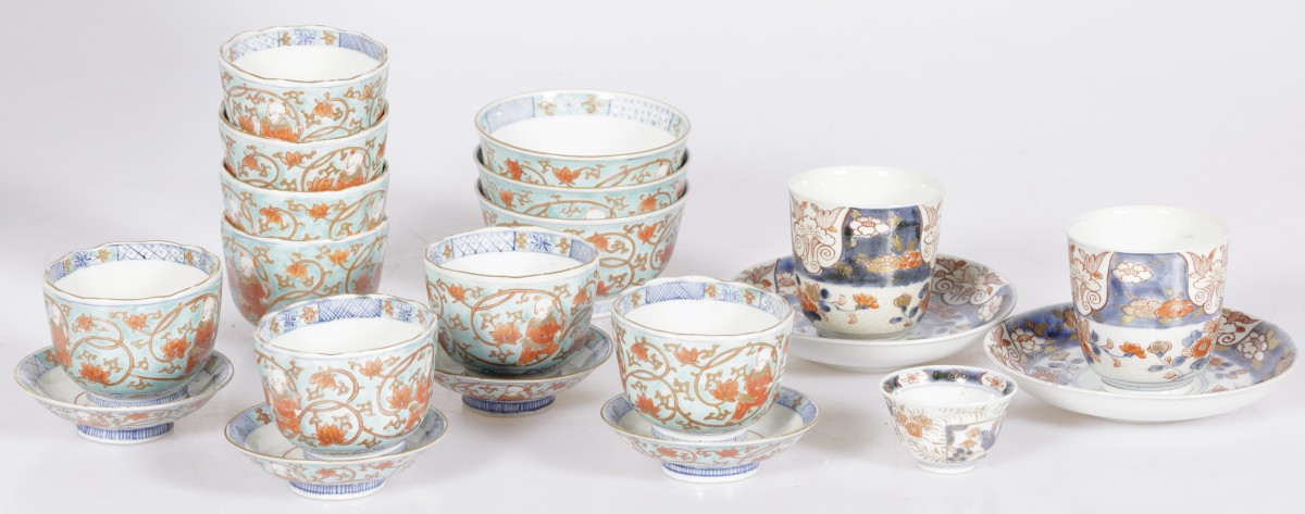Een lot divers porselein waaronder kop-en-schotels met Imari decor en een set dekselkopjes gedecoreerd met zotjes, Japan, 19e eeuw.