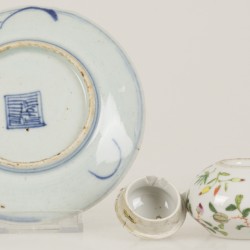 Een porseleinen miniatuur theepotje met Kanton decor en daarbij een floraal gedecoreerd schoteltje, China, eind 19e eeuw.