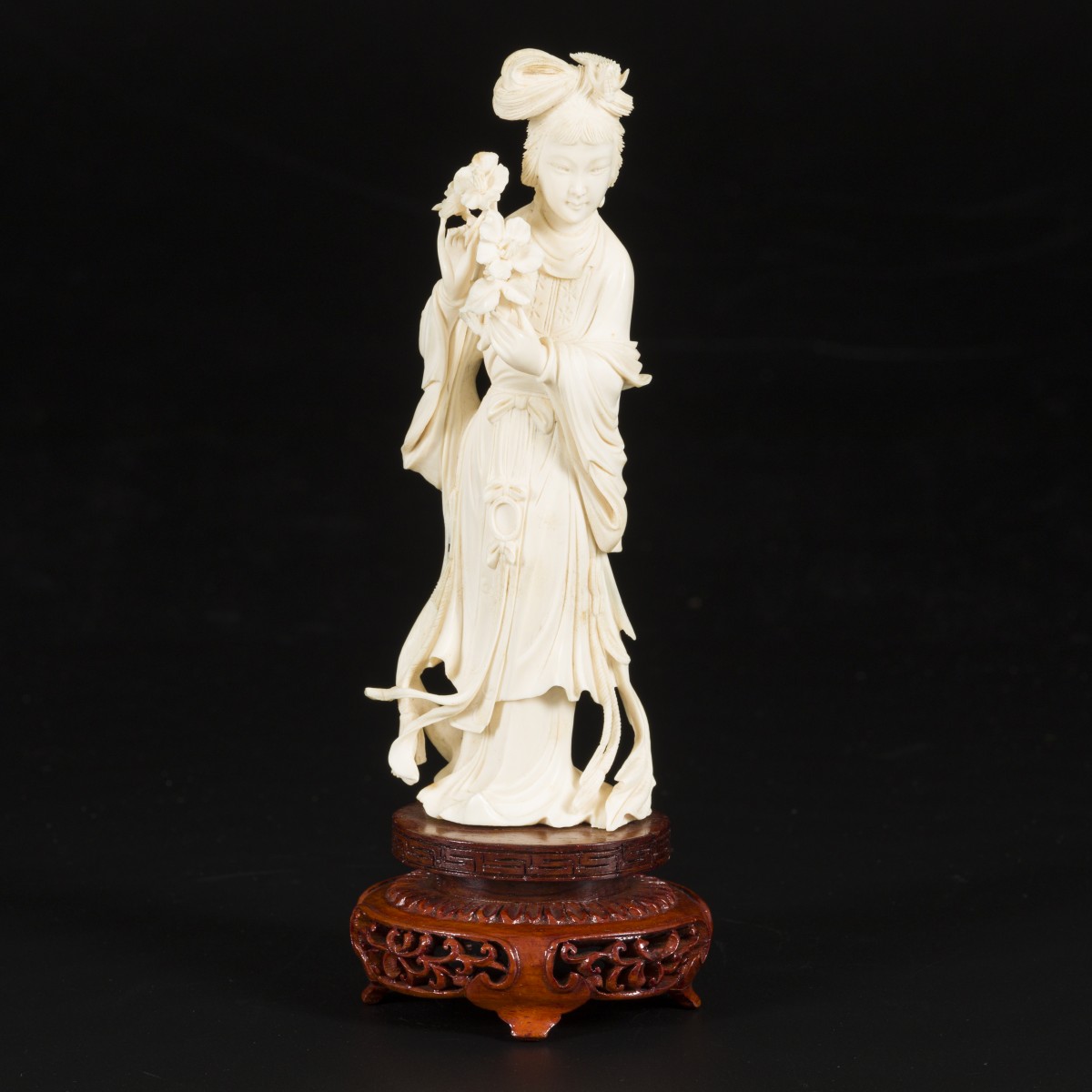 Een ivoren Guanyin op houten sokkel, China, begin 20e eeuw.