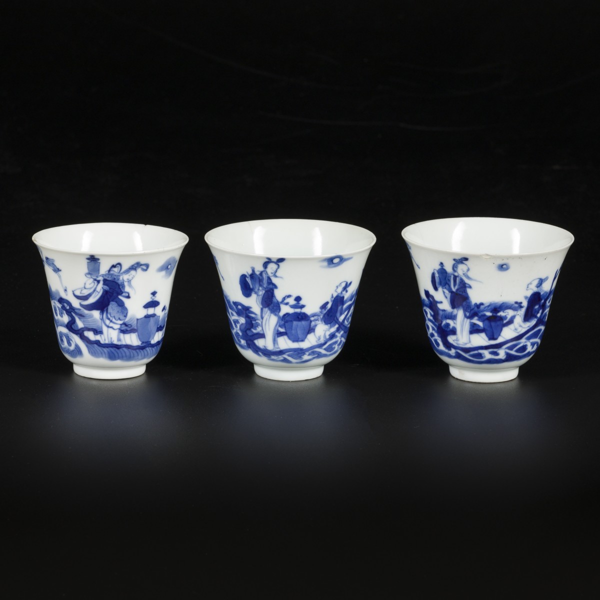 Een set van (3) porseleinen cups met decor van Chinese figuren, China, Kangxi.