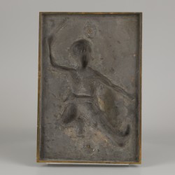 Een bronzen plaquette met voorstelling van een dansende kozak.