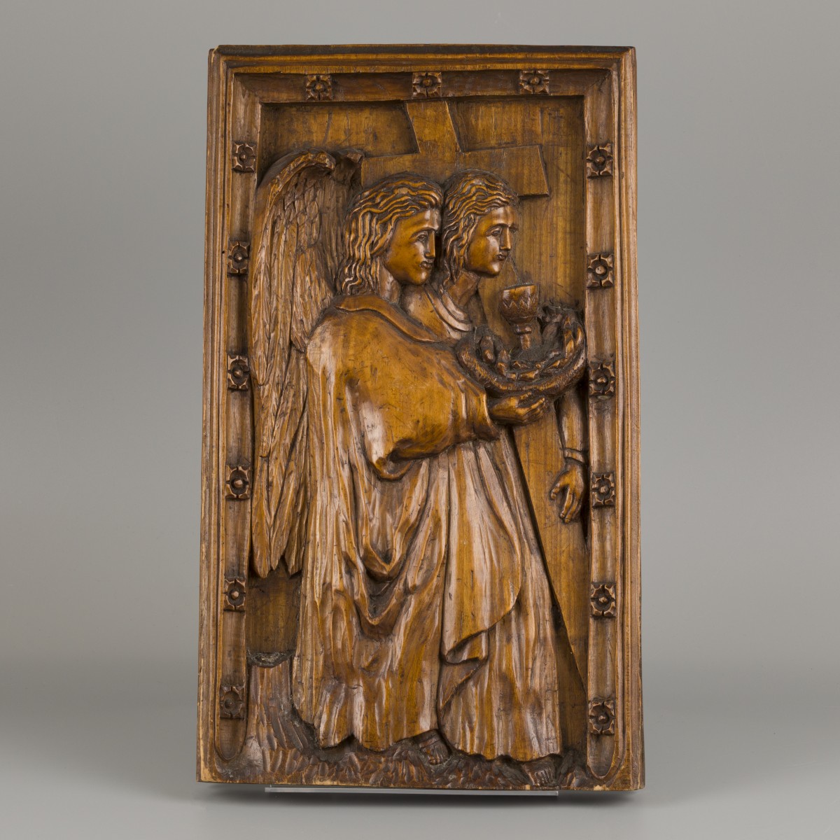 Een eiken bas-reliëf met voorstelling van Johannes de evangelist met arma sacra, ca. 1900.