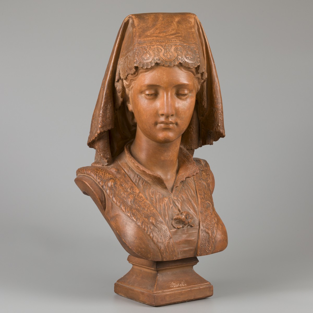 Een terracotta buste van een jonge vrouw in Franse klederdracht.
