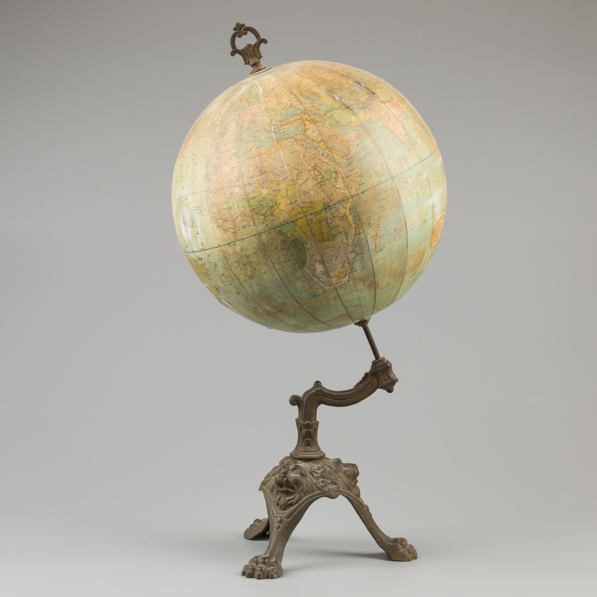 Een "E. Girard & A. Boitte, Parijs" wereldglobe op metalen gegoten voet met leeuwenkoppen en klauwvoeten, ca. 1900 - 1920.