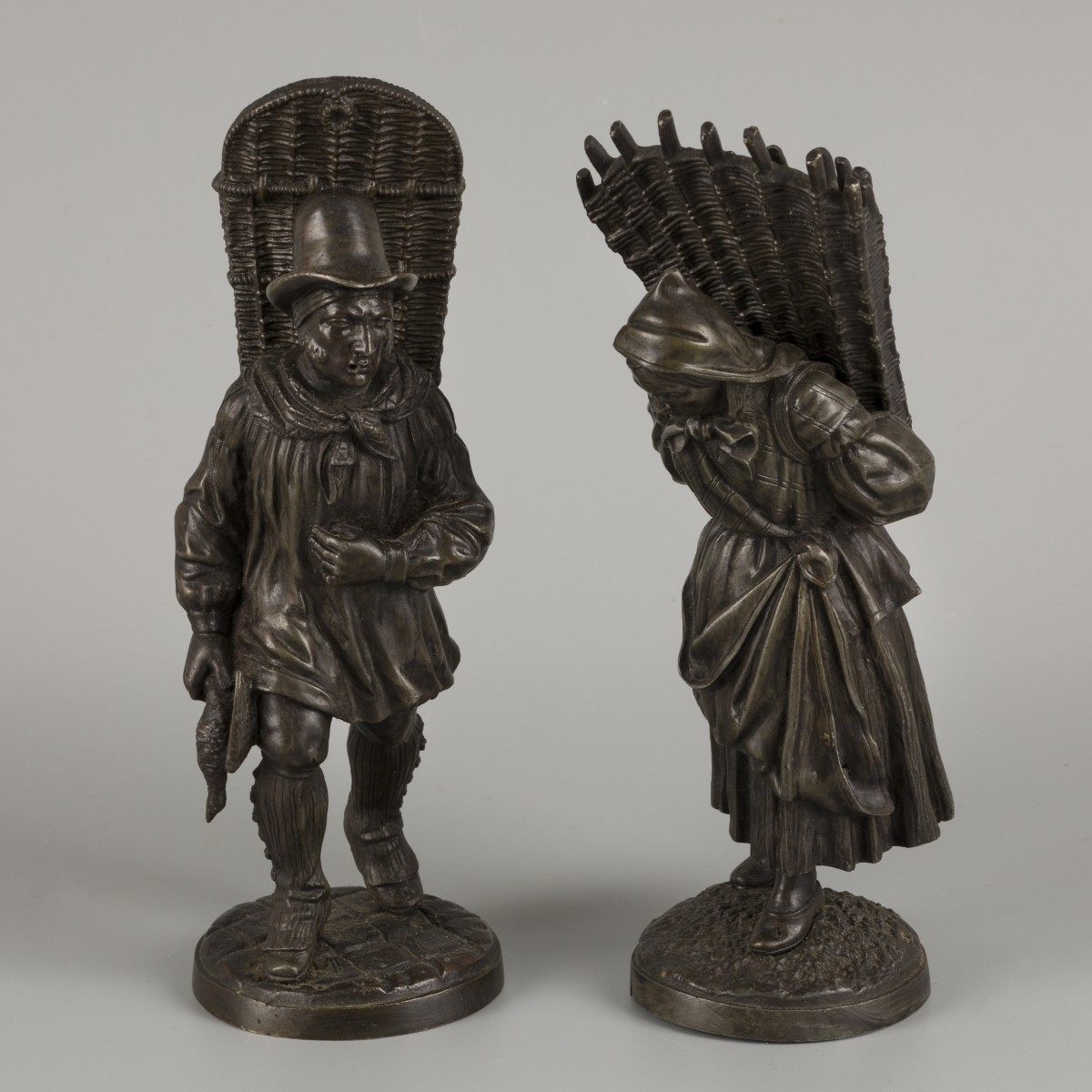 Een set van (2) bronzen figuurtjes in de vorm van  een eendenfokker en een houtsprokkelaarster, 20e eeuw.