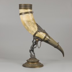 Een drinkhoorn vervaardigd van een ossenhoorn, gedragen door een putto, ca. 1920.