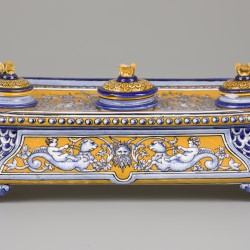 Een majolica inktstel gedecoreerd met putti gezeten op zeemonsters en diverse leeuwenmascarons, Italië, circa 1900.