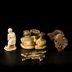 Een lot met (4) objecten voorstellende een broche van een strijder, (2) netsukes en een kleine okimono, einde Meiji periode.