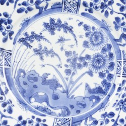 Een porseleinen bord met 4-vaks buitenrand decor, centrum floraal met vogel, China, Kangxi.