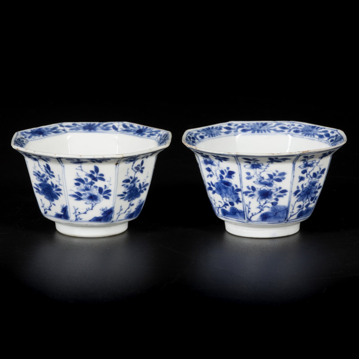 Een set van (2) porseleinen klapmutskommetjes met floraal decor, gehoekt model, China, Kangxi, 18e eeuw.