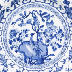 Een geribd porseleinen bord met decor van vogel op rots, China, Kangxi.