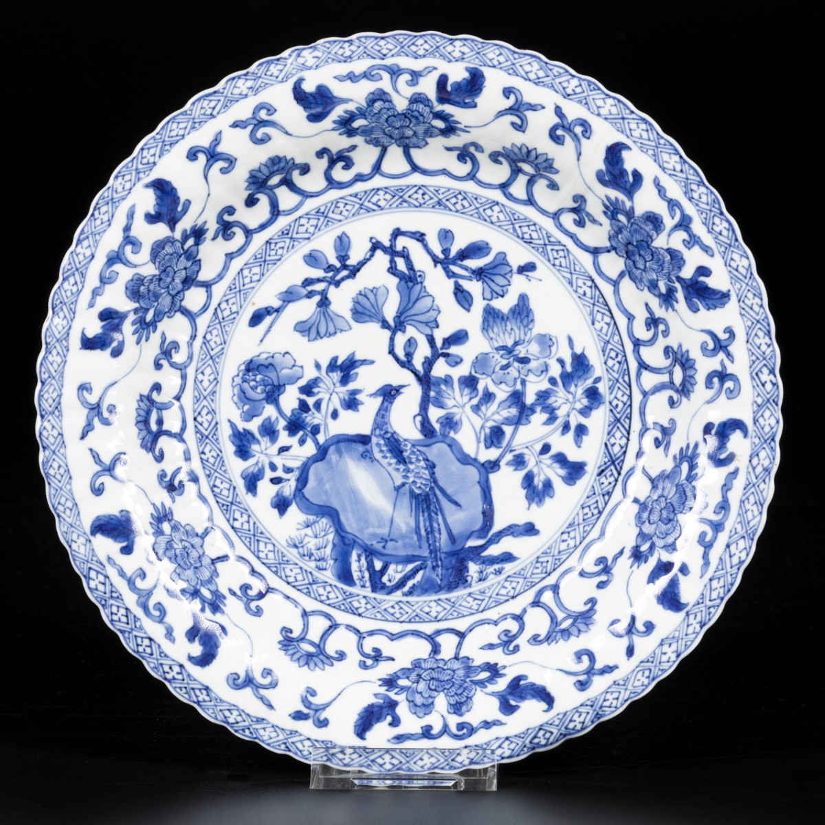 Een geribd porseleinen bord met decor van vogel op rots, China, Kangxi.