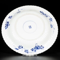 Een geribd porseleinen bord met decor van vogel op rots, China, Kangxi.