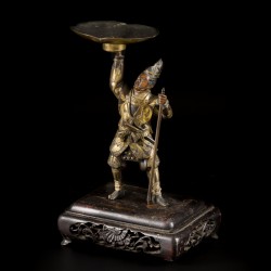 Een lot van (2) bronzen kandelaren waarvan één op houten voet, 19e/20e eeuw.