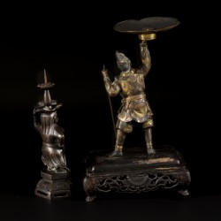 Een lot van (2) bronzen kandelaren waarvan één op houten voet, 19e/20e eeuw.