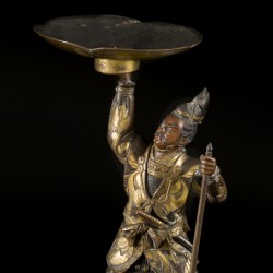 Een lot van (2) bronzen kandelaren waarvan één op houten voet, 19e/20e eeuw.
