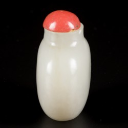 Een celadon jade snuff bottle met bloedkoralen dop, China, 19e eeuw.