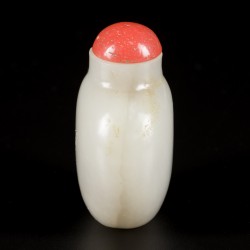 Een celadon jade snuff bottle met bloedkoralen dop, China, 19e eeuw.