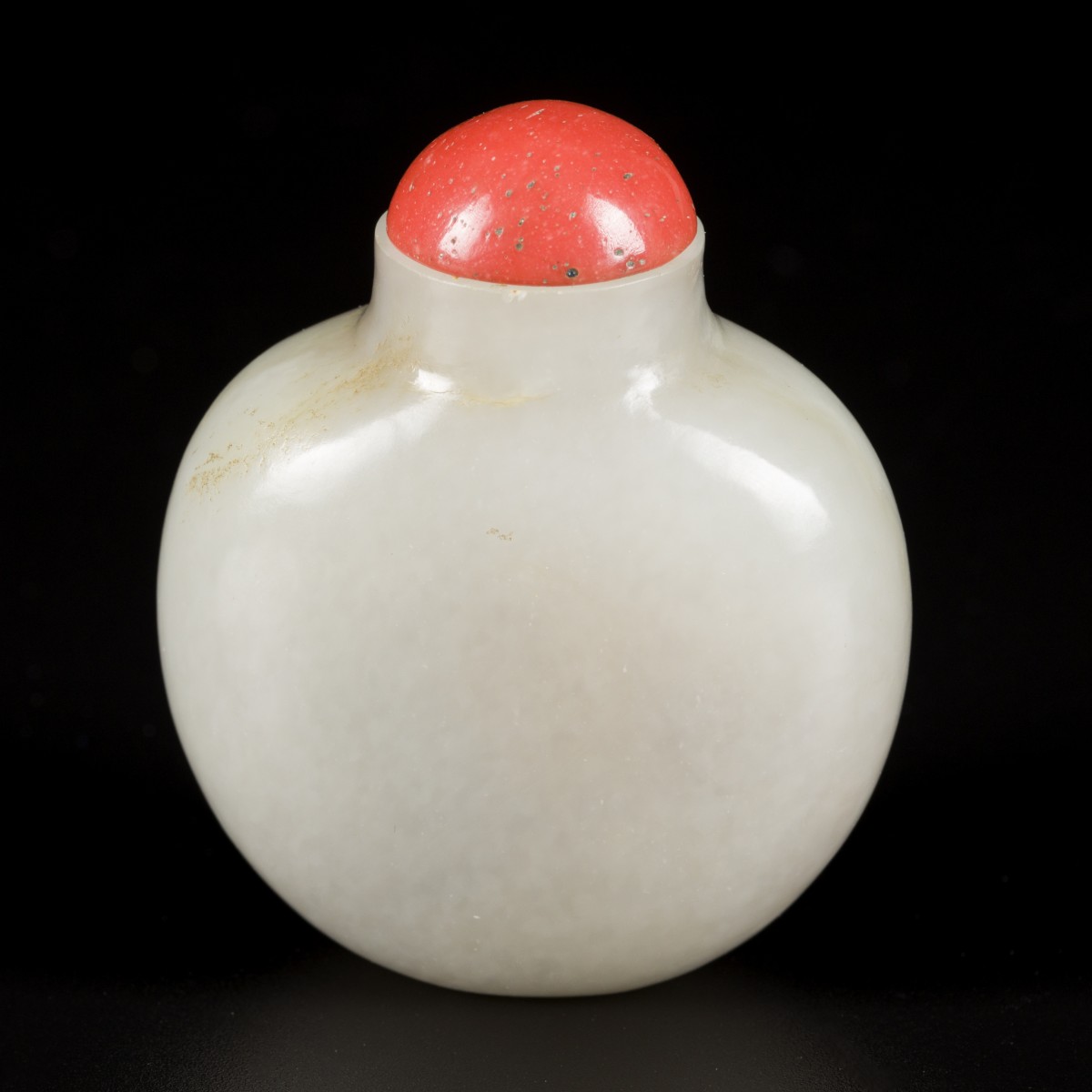 Een celadon jade snuff bottle met bloedkoralen dop, China, 19e eeuw.