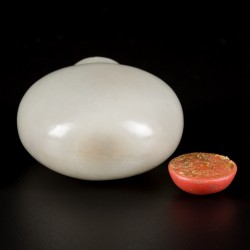 Een celadon jade snuff bottle met bloedkoralen dop, China, 19e eeuw.