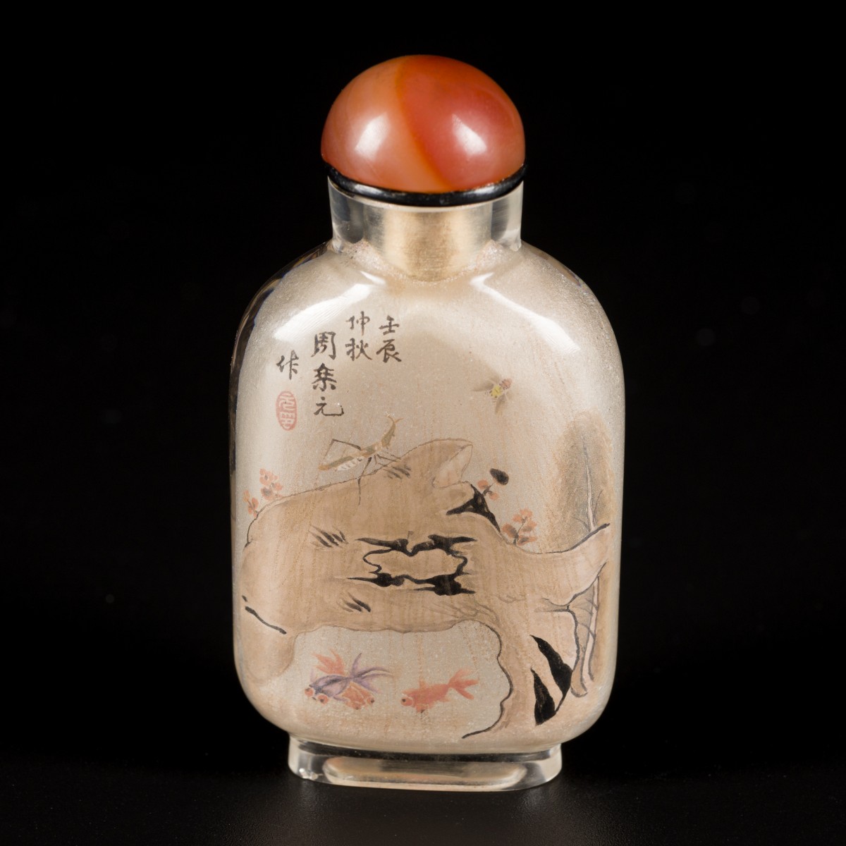 Een glazen snuff bottle gedecoreerd met goudvissen en schatten.