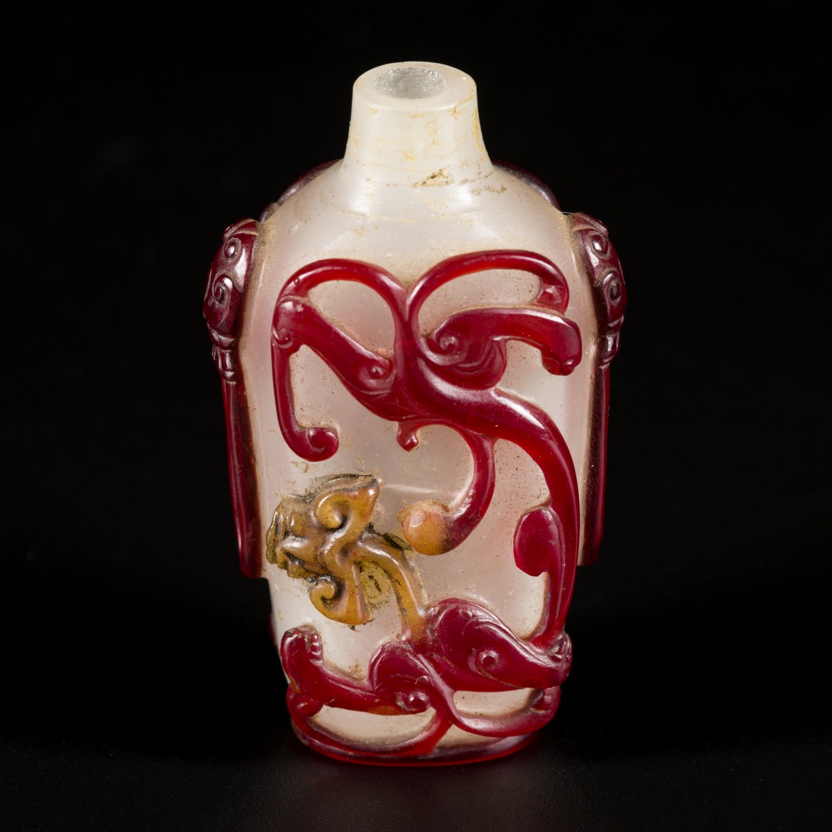 Een glazen snuff bottle gedecoreerd met rode draken, China, circa 1800.