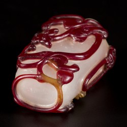Een glazen snuff bottle gedecoreerd met rode draken, China, circa 1800.
