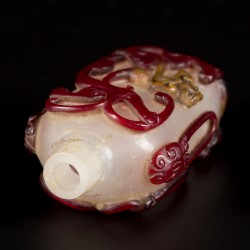 Een glazen snuff bottle gedecoreerd met rode draken, China, circa 1800.