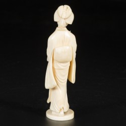 Een ivoren sculptuur in de vorm van een dame met parasol. Japan, einde Meji-periode.