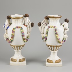 Een set van (2) porseleinen vazen gedecoreerd met bloemen, ramskoppen en kinderen, Sitzendorf, eind 19e eeuw.