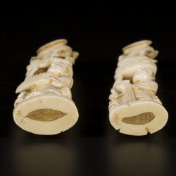 Een set van (2) ivoren okimonos in de vorm van Japanse heren met dierlijke figuren, Japan, eind Meji-periode.