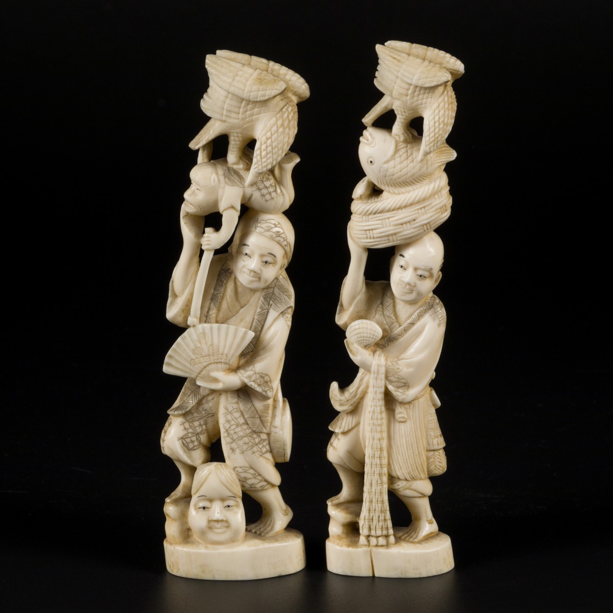 Een set van (2) ivoren okimonos in de vorm van Japanse heren met dierlijke figuren, Japan, eind Meji-periode.