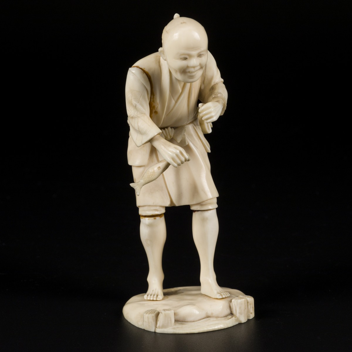 Een ivoren sculptuur in de vorm van een visser, Japan, einde Meji-periode.