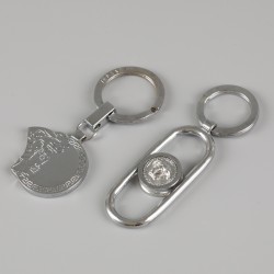Een lot bestaande uit twee sleutelhangers, een bidprentje van Gianni Versace en de catalogus van de collectie van Gianni Versace (Sotheby's Mei 2005).