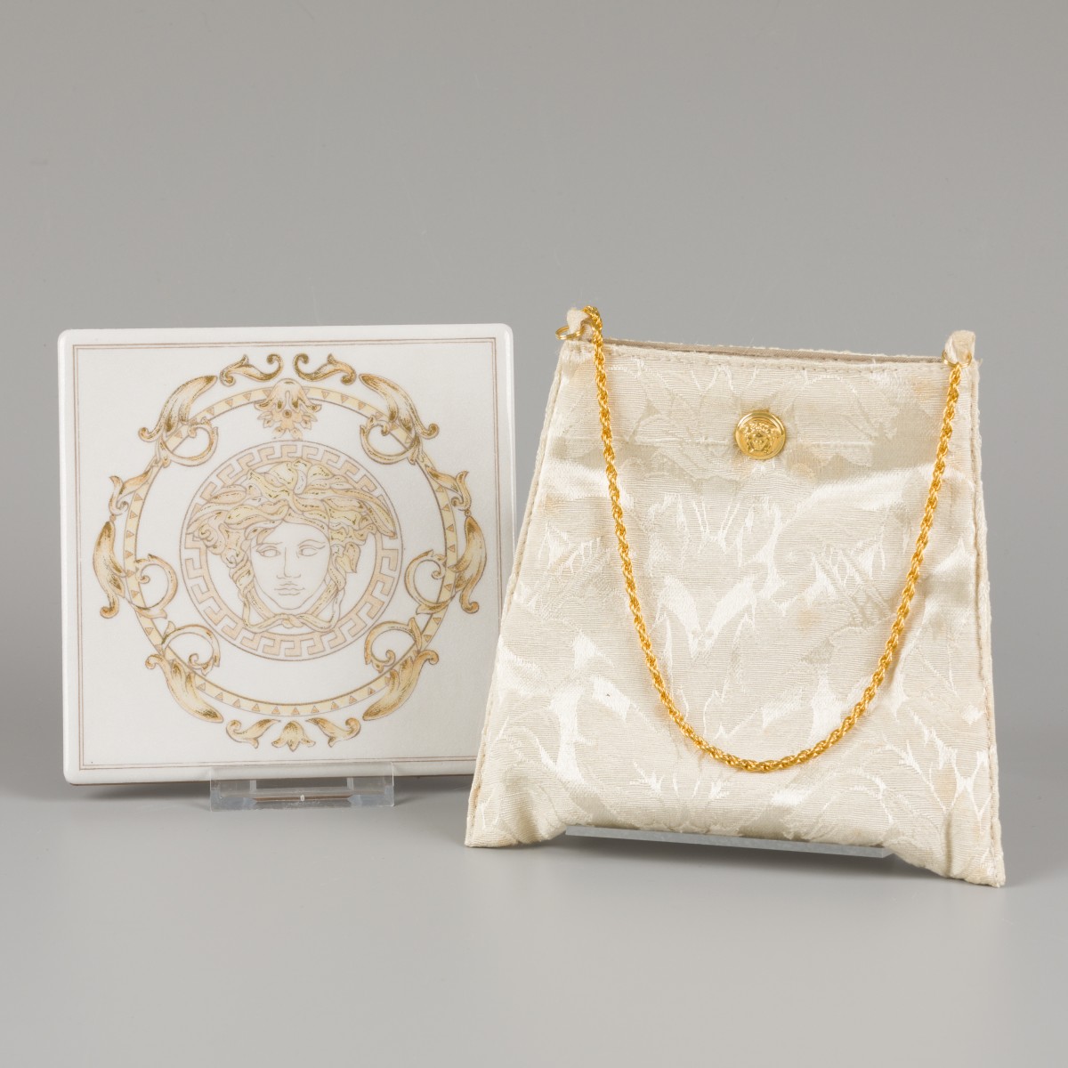 Een lot bestaande uit een handtasje en tegel gedecoreerd met Medusa. Versace.
