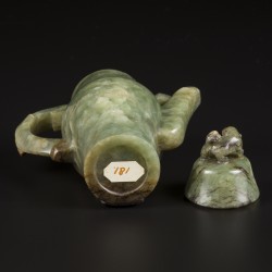 Een Celadon jade theepotje gedecoreerd met leeuw als dekselknop en reliëfdecor van een vogel en prunus. China, 19e eeuw.