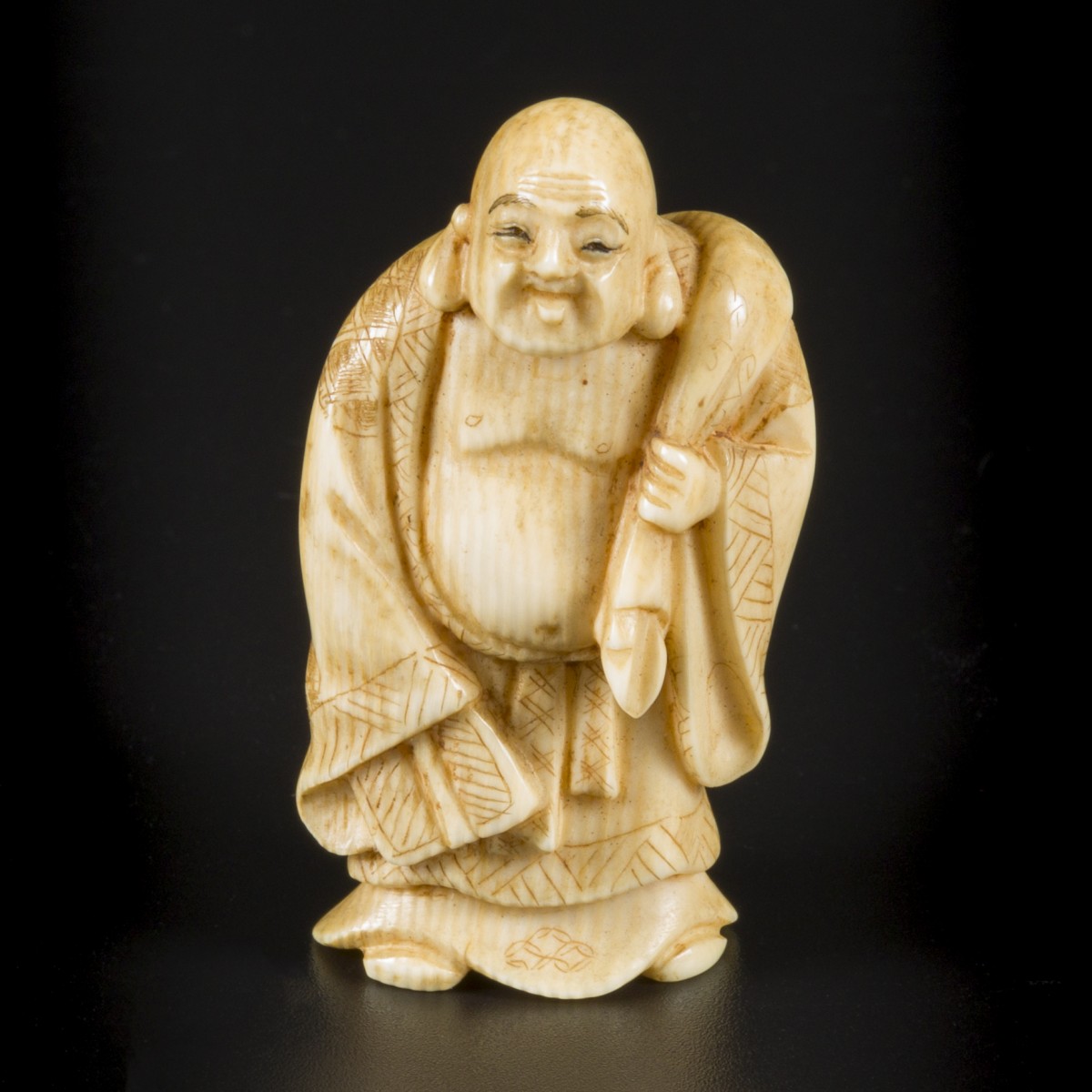 Een ivoren okimono van een lachende Buddha als reiziger, Japan, Meiji periode, ca. 1910.